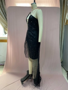 Detail eines schwarzen Pailletten-Cocktailkleids mit asymmetrischem Saum aus Netzstoff