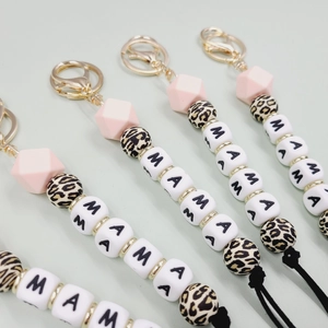 Detail of MAMA silicone bead keychains with leopard print and golden lobster clasp