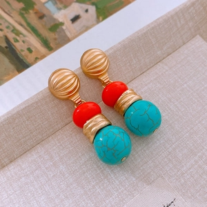 Detailed close-up of vintage tricolor drop earrings with gold knurled textures