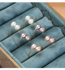 Detailed close-up of colorful freshwater pearl rings in gold twisted settings