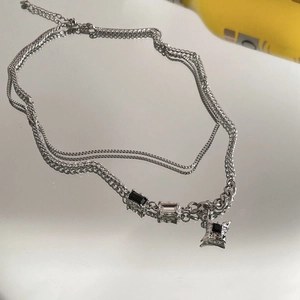 Detailed macro view of silver layered necklace with black rectangle stones and star pendant