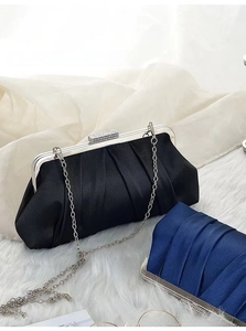Detail of pleated satin evening clutch with rectangular rhinestone clasp and silver chain