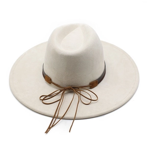 Dettaglio cappello fedora beige in camoscio con fascia in pelle marrone e fiocco