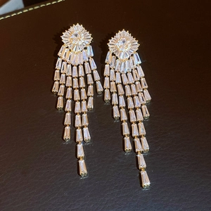 Primo piano di orecchini a fiore dorati vintage con eleganti nappe di strass brillanti