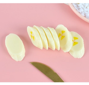 Macro shot of realistic PVC banana slice models with detailed textures on pink background