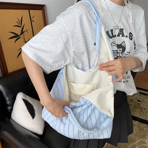 Detail view of the large capacity striped canvas bag showing internal zipper pocket