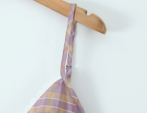 Detail of purple and yellow plaid top with white lace trim and adjustable thin straps