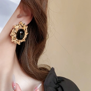 Nahaufnahme von Vintage-Ohrring in Gold mit schwarzem Edelstein und Blattverzierung