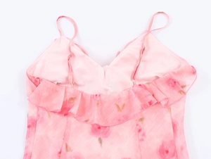 Detail eines rosa Blumenkleides mit zarten Rüschen, dünnen Trägern und V-Ausschnitt