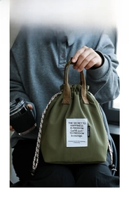 Detail of army green insulated lunch bag with drawstring closure and woven handles