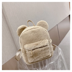 Detail showing the soft plush texture and cute round bear ears on the beige backpack