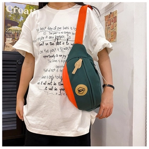 Detail of multi-color crossbody bag in green and orange with leather HX logo on front