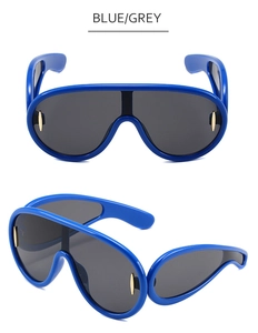 Detail of oversized blue frame sunglasses with grey lenses and stylish one-piece design