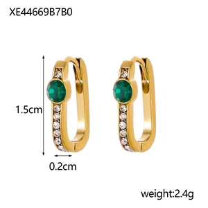 Detail of U-shaped gold earrings with green main stone and white cubic zirconia