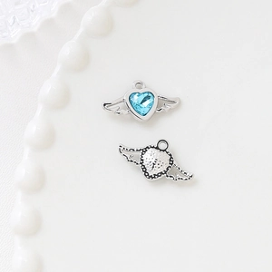 Detail of silver heart charm with wings and blue zircon stone for DIY jewelry making