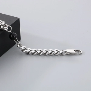Detail of silver titanium chain bracelet featuring a black bead and lobster clasp closure