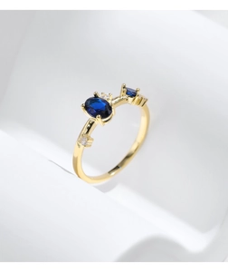 Detail eines vergoldeten s925 Silberrings mit zwei blauen Steinen und klarem Steinbesatz