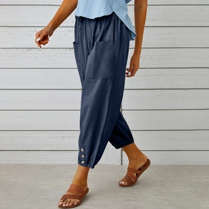 Dettaglio dei pantaloni in cotone e lino blu navy con bottoni decorativi sui polsini delle gambe