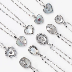 Flat lay of vintage shell pendants on silver stainless steel necklaces for women