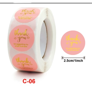 Detail of 1-inch pink thank you sticker roll with gold lettering for small business