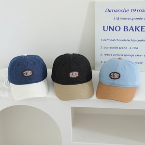 Detailed view of color-block denim baseball caps with CQYRXD embroidered letter patches