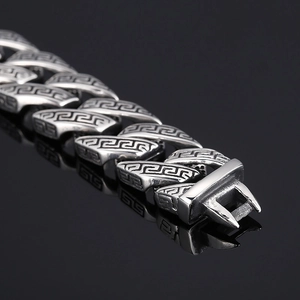 Macro view of silver stainless steel chain bracelet with Greek key pattern and clasp