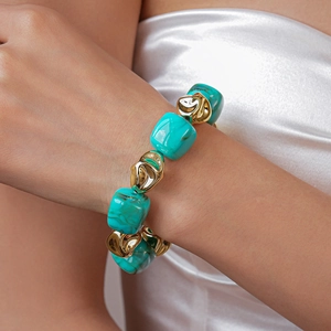 Detail of irregular turquoise and gold beads on a geometric necklace for women