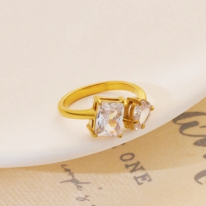 Detailed macro view of gold adjustable ring featuring emerald and heart-cut zircons