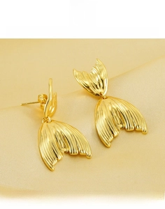 Détail de boucles d'oreilles queue de poisson en or 18K et acier titane sur soie