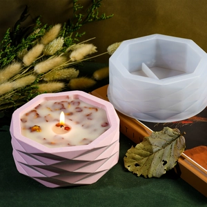 Detail of white faceted silicone mold with a finished pink geometric candle jar on a desk
