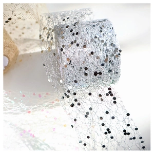 Macro shot of silver mesh ribbon with hexagonal sequins for DIY gift and floral wrap