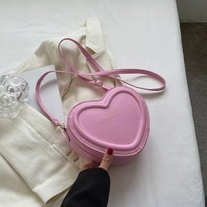 Dettaglio della borsa a tracolla rosa a forma di cuore con scritta dorata Fashion & Bag
