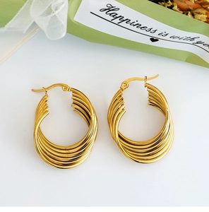 Close-up of golden multi-layer twisted hoop earrings with a textured hinge design