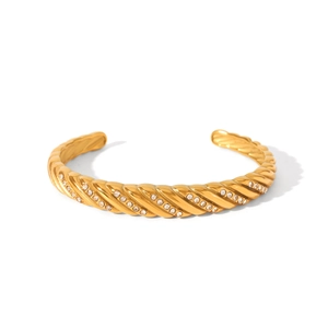 Close-up of 18K gold stainless steel twisted bangle with sparkling pavé crystal detail
