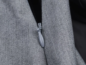 Macro shot of grey crepe fabric texture and seamless zipper detail on women dress