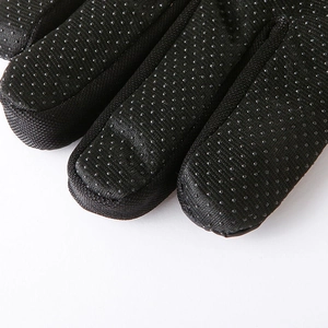 Close-up of black winter thermal gloves showing anti-slip silicone grip on fingertips