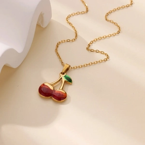 Elegant gold chain necklace with a realistic red and green cherry fruit pendant