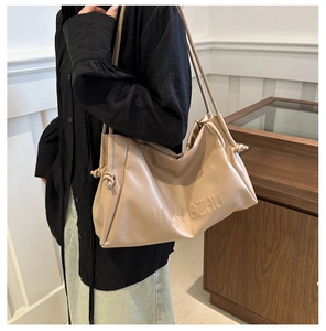 Detailed side view of apricot PU leather tote bag with drawstring and VVCNOGZHU logo