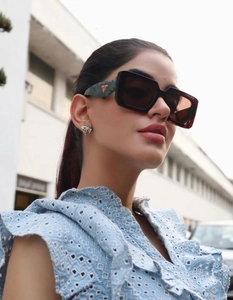 Close-up of square flat top sunglasses with dark lenses and green marble temples