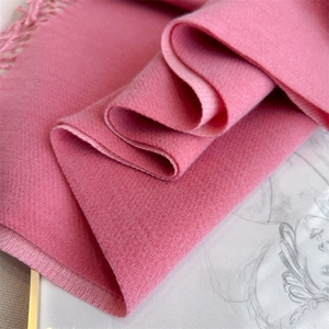 Detail of pink herringbone cashmere scarf showing soft texture and fringe tassels
