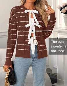 Detail of cable knit cardigan texture with white ribbon ties and no lining