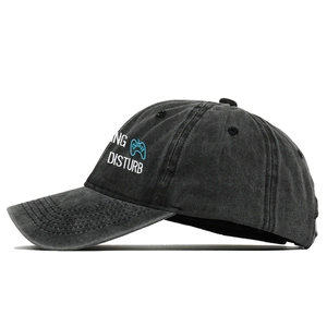 Detail of black washed cotton baseball cap with game controller embroidery on the side