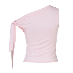 Détail du haut rose clair à une épaule avec nœud élégant et longs rubans décoratifs