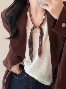 Bohemian paisley fabric scarf necklace styled with brown resin and wood beads on a model