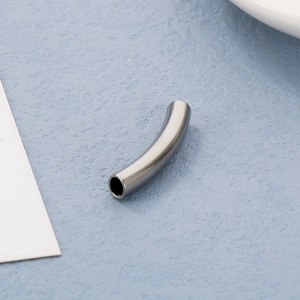 Macro shot of curved gunmetal hollow tube bead for DIY jewelry and necklace crafting