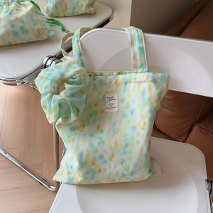 Detailed close-up of mint green tie-dye canvas bag with matching scrunchie and pouches