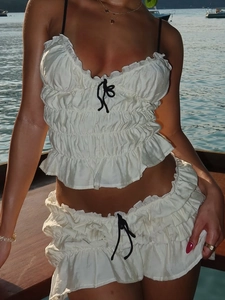 White pleated chiffon two-piece set with black bows featuring crop top and mini skirt
