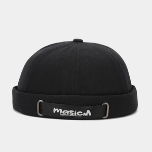Détail du bonnet docker noir avec ruban brodé et boucle en métal pour un style urbain