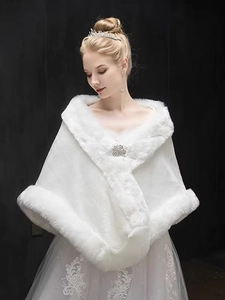 Close-up of white faux fur bridal shawl with an elegant brooch and soft texture details