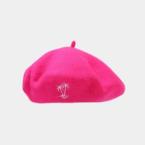 Detailed close-up of palm tree embroidery on a rose pink wool beret for women